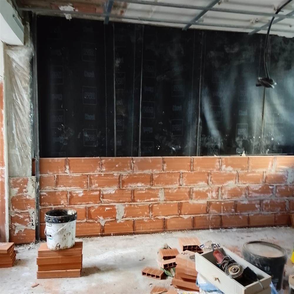 Fachada de ladrillo con lámina impermeabilizante durante una rehabilitación de fachada