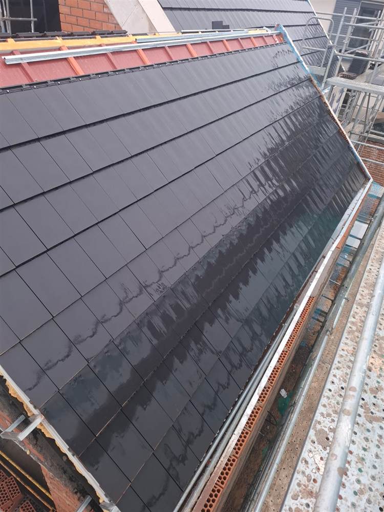 Detalle de cubierta terminada con tejas negras tras la reforma del tejado